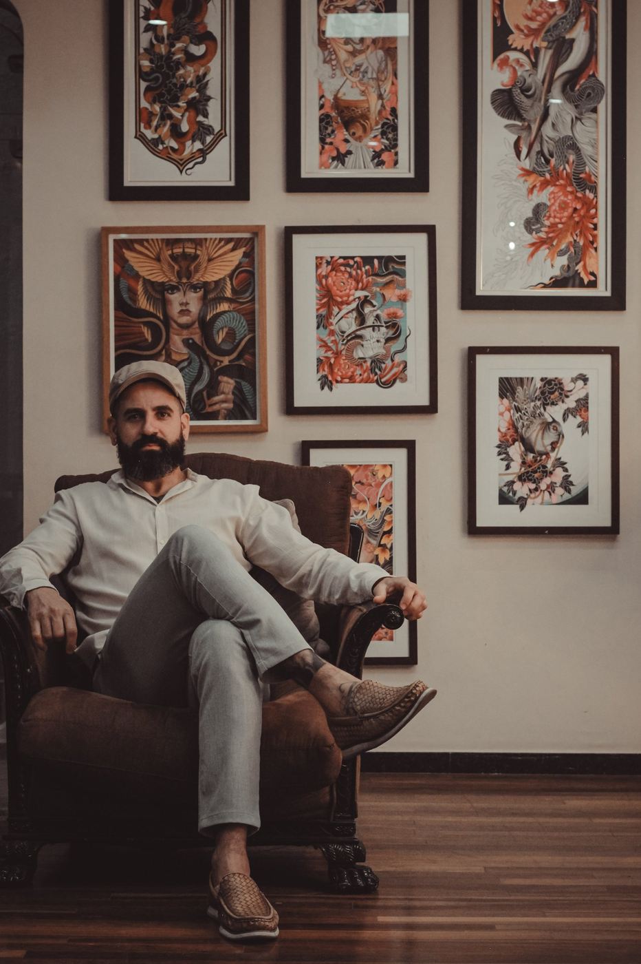 Denis Vazios em seu ateliê, cercado pela própria obra emoldurada